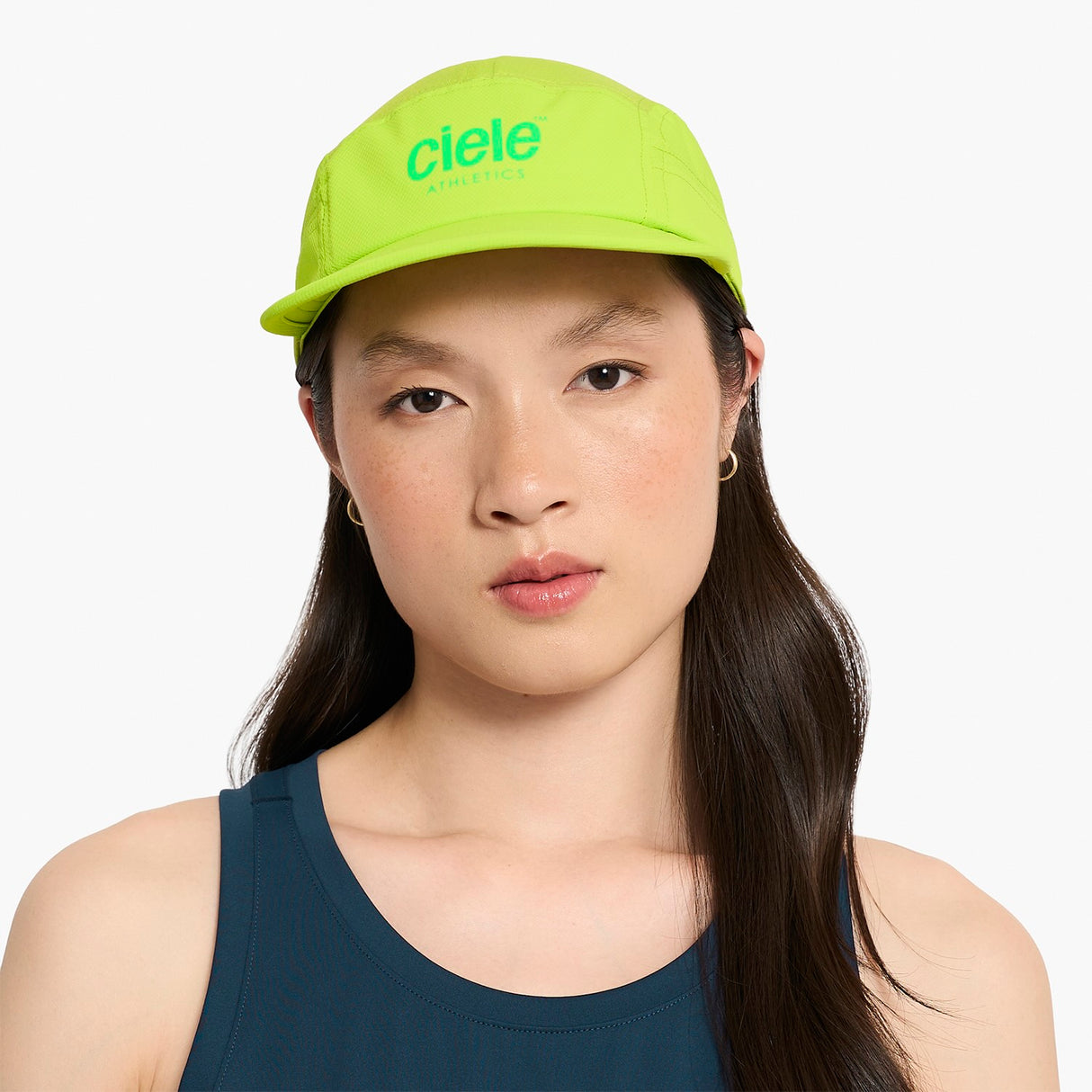 Person wearing a Ciele Athletics GOCap Classic - Athletics Lime Green running cap with 'Ciele' branding on a white background