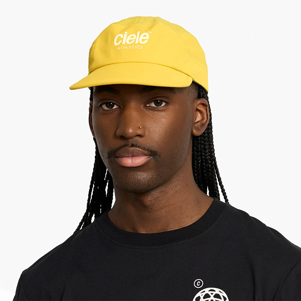 Person wearing a yellow ciele athletics GOCap Classic - Athletics in Sulfur with 'Clele' branding on a white background