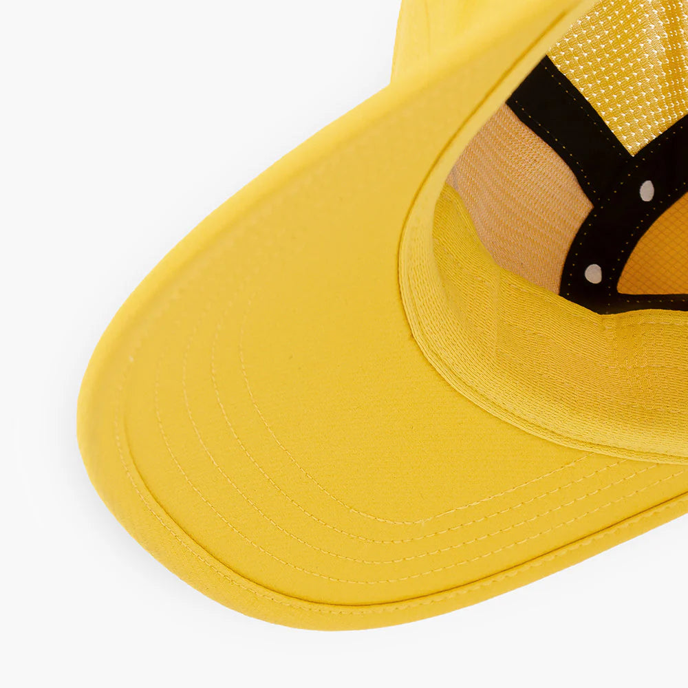 Close-up of a yellow ciele athletics GOCap Classic - Athletics in Sulfur with a mesh design on a white background
