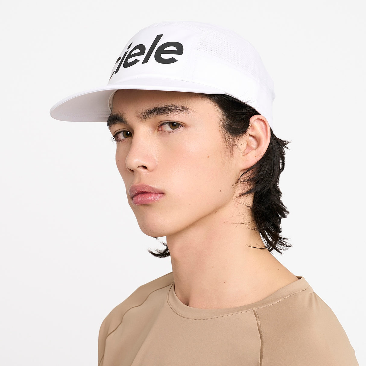 Person wearing a Ciele Athletics GOCap Comp Century Trooper white running cap on a white background