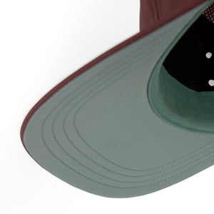 Close-up of a ciele athletics GOCap Comp - Bars Dark Wine Red running cap on a white background