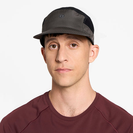 Man wearing a Ciele Athletics GOCap Icon - Circle C in Shadowcast performance running hat and maroon shirt on a white background