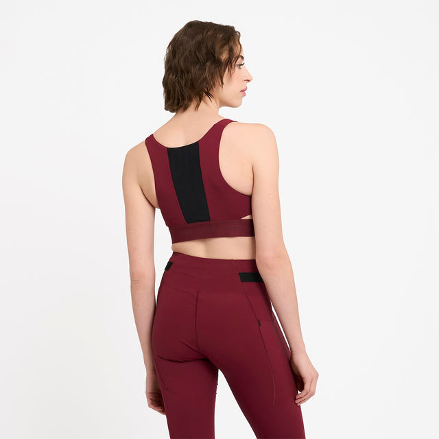 Woman wearing Ciele Athletics Women's QCKBra Sports Bra in Crimson Red Maroon sports bra on a white background