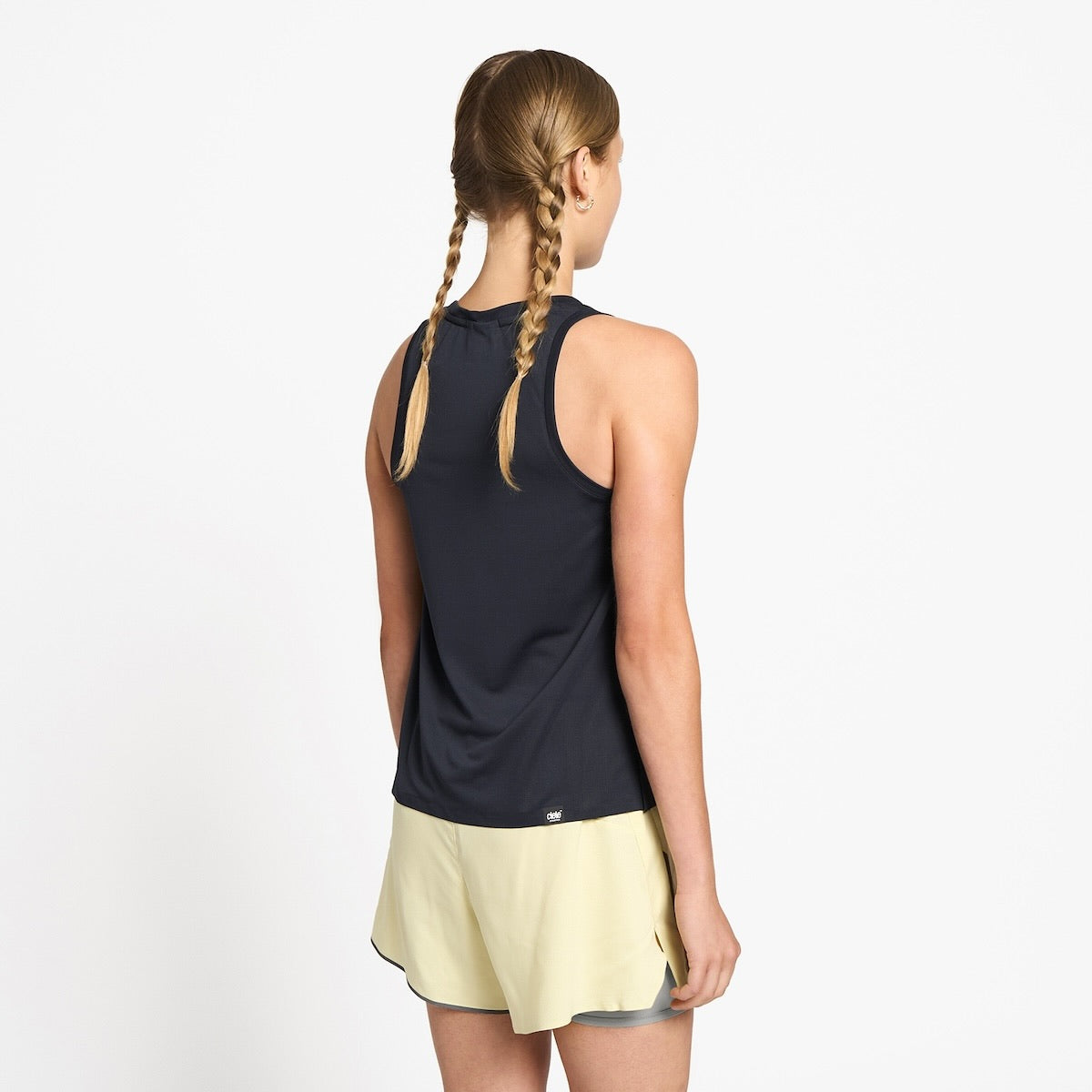 Ciele Athletics W FSTSinglet women's running tank top in Shadowcast worn by a woman runner on a neutral background.