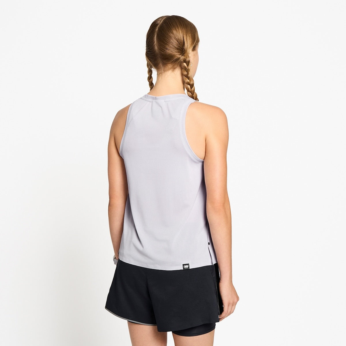 Ciele Athletics W FSTSinglet women's running tank top in Misty Lilac worn by a woman runner on a neutral background.