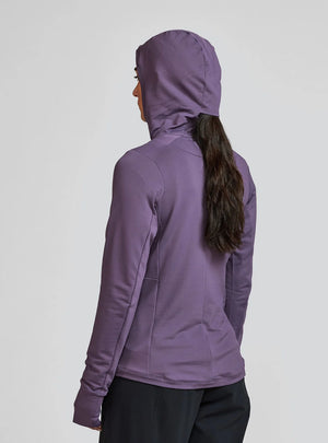 Janji W's Rover Merino Hoodie for women in Massif worn by a woman from the rear on a neutral background.