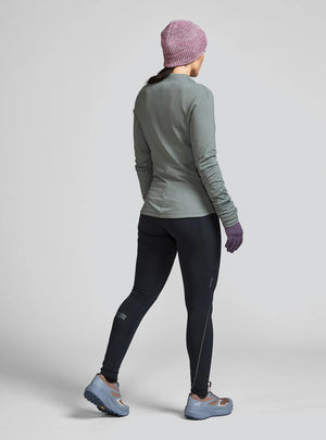 Janji women's Aurora Fleece Tight worn by a woman from the rear on a neutral background.