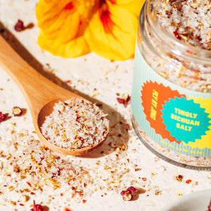 JSC x Fly By Jing Tingly Sichuan Salt with wooden spoon and jar on a light background