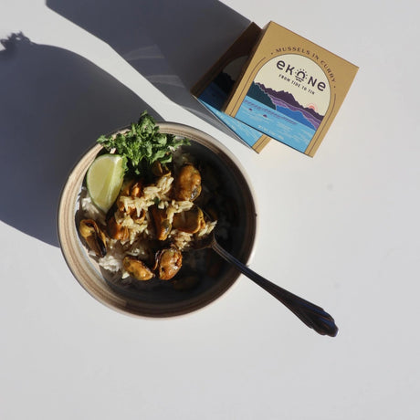 Ekone Mussels in Curry tinned seafood mixed in a rice bowl on a neutral background.