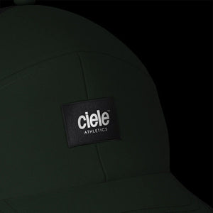 Ciele Athetics TRKCap SC - Box in Acres on a dark background from the front showing the reflective detailing.