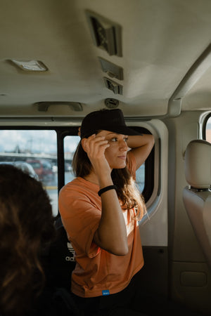 Janji's Circa Boxy Daily Tee in Amphora being worn by a women in a car.