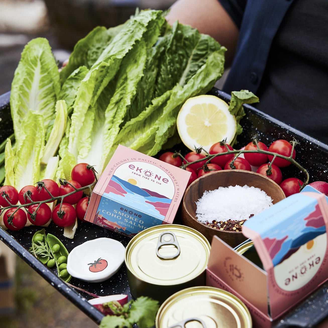 Ekone Smoked Coho Salmon tinned fish packaging on a plate with vegetables.