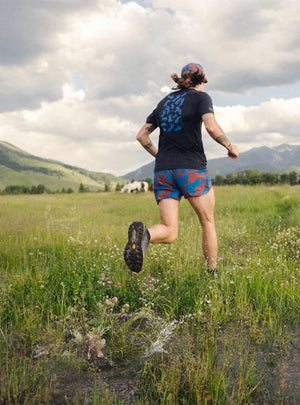 Janji Men's 5" AFO Middle Short in Cobalt Horses worn by a runner outdoors.