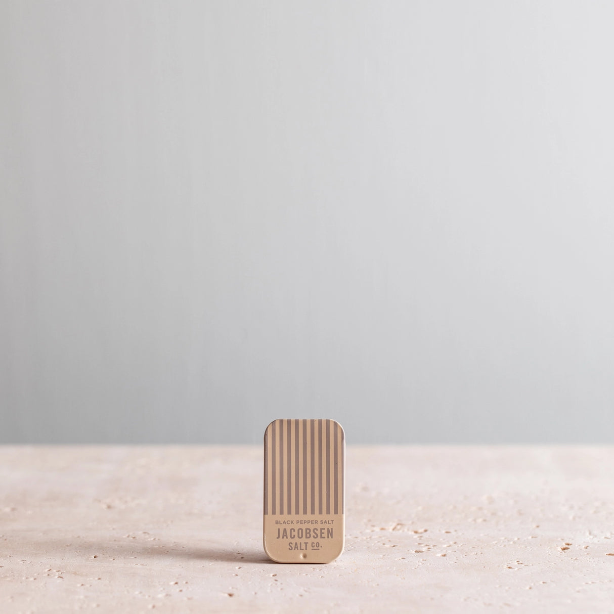 Jacobsen Salt Co. Infused Black Pepper Sea Salt Slide Tin on a light gray background