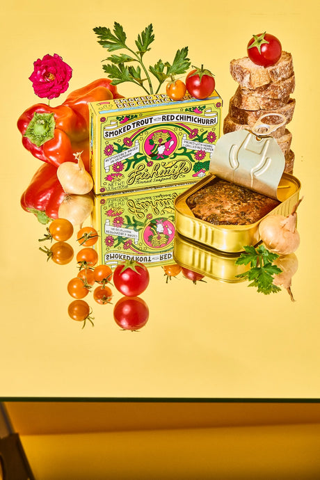 Fishwife Smoked Rainbow Trout with Red Chimichurri with packaging and fresh ingredients on a yellow background