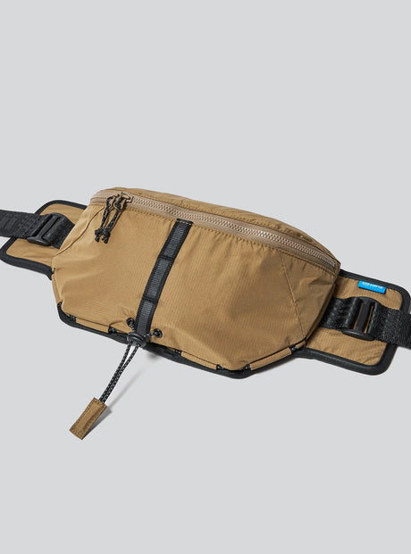 Janji Multipass Sling Bag in Forage on a neutral background.