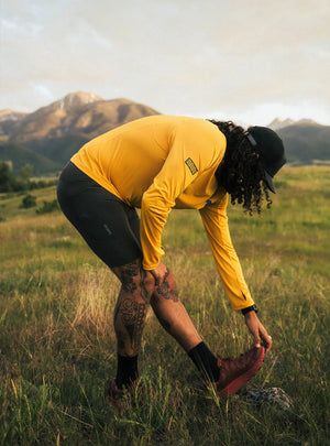 Janji M's Run All Day Long Sleeve in Golden Blue Horses being worn outside in a field.