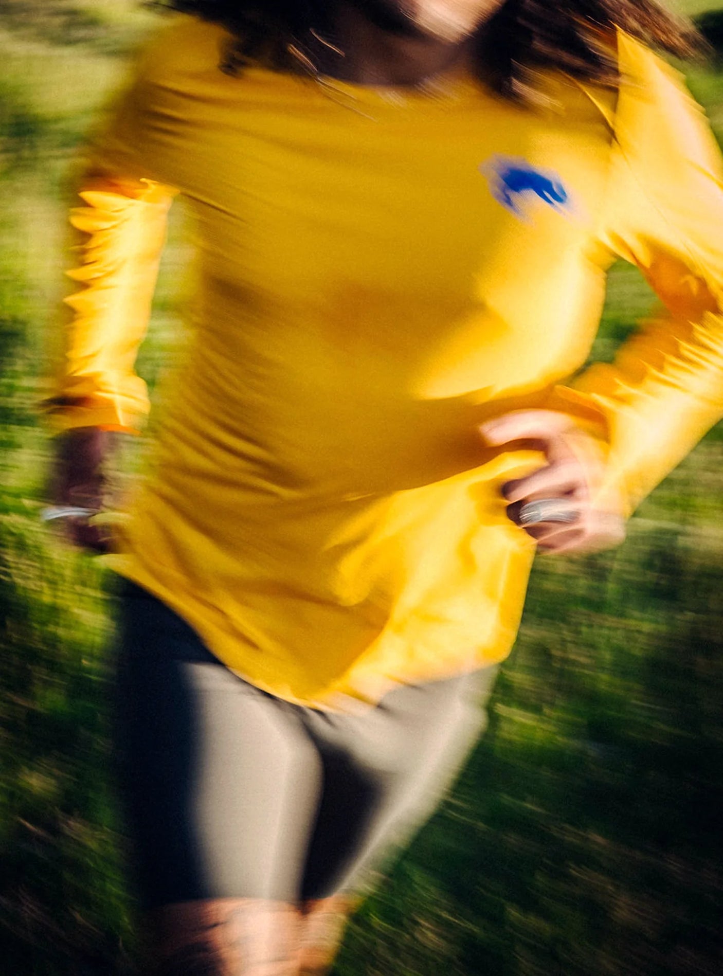 Janji M's Run All Day Long Sleeve in Golden Blue Horses being worn outside by a runner.