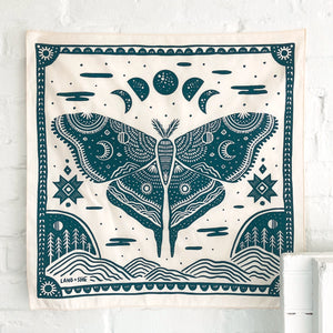 Land & She Luna Moth Bandana on a neutral brick background.