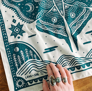 Land & She Luna Moth Bandana on a wood background with a hand pictured.