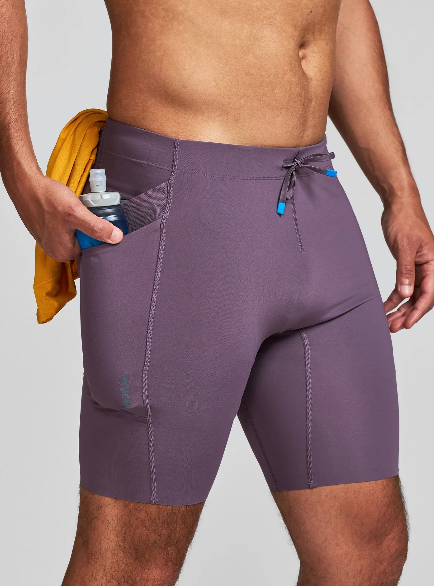 Janji Men's 8" Trail Half Tight in Massif worn by a man on a neutral background.