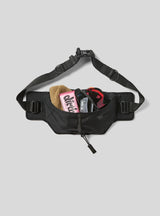 Janji Multipass Sling Bag on a neutral background, showing how much it can store.