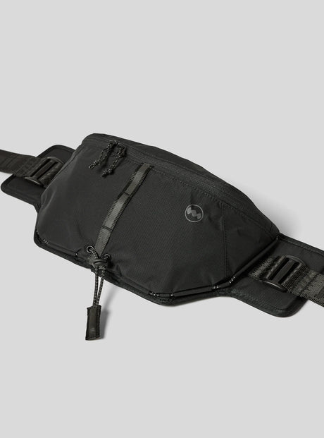 Janji Multipass Sling Bag on a neutral background at an angle.