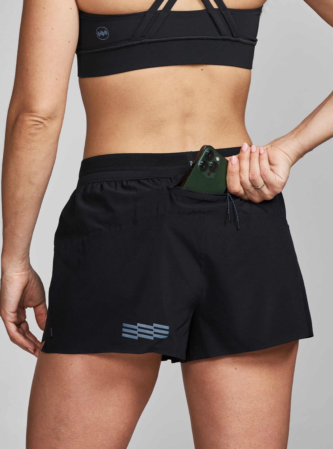 Janji's Women's 3" AFO Middle Short in Midnight from the rear to show the waist pocket.