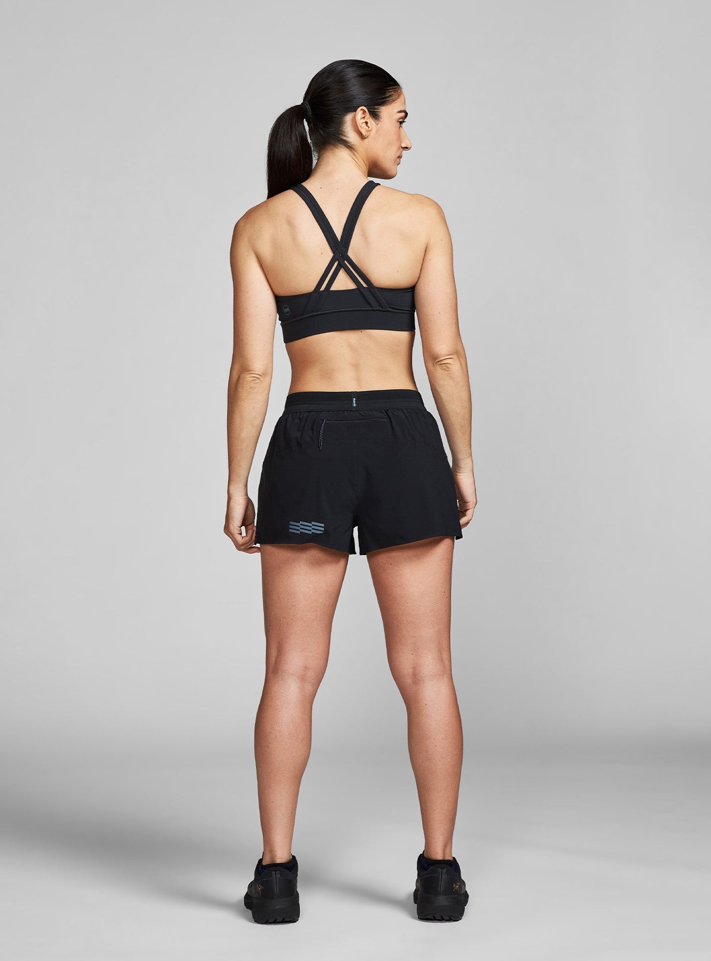 Janji's Women's 3" AFO Middle Short in Midnight being worn by a woman from the rear.