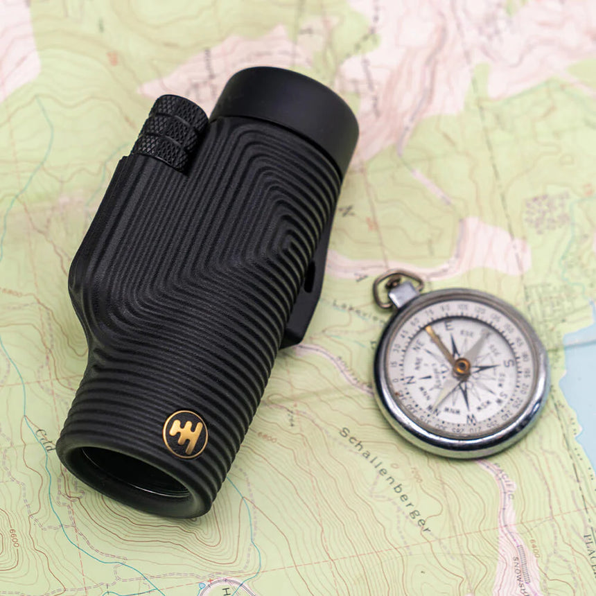 Nocs Provisions Zoom Tube 8x32 Monocular in Obsidian Black on a map background.