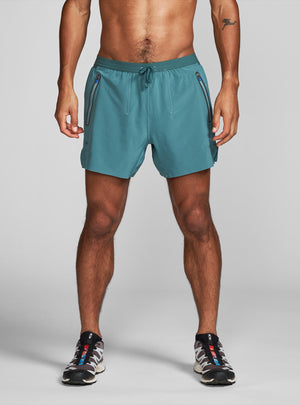 Janji's 5" AFO Middle Short Ultra in Plateau being worn by a man on a neutral background.