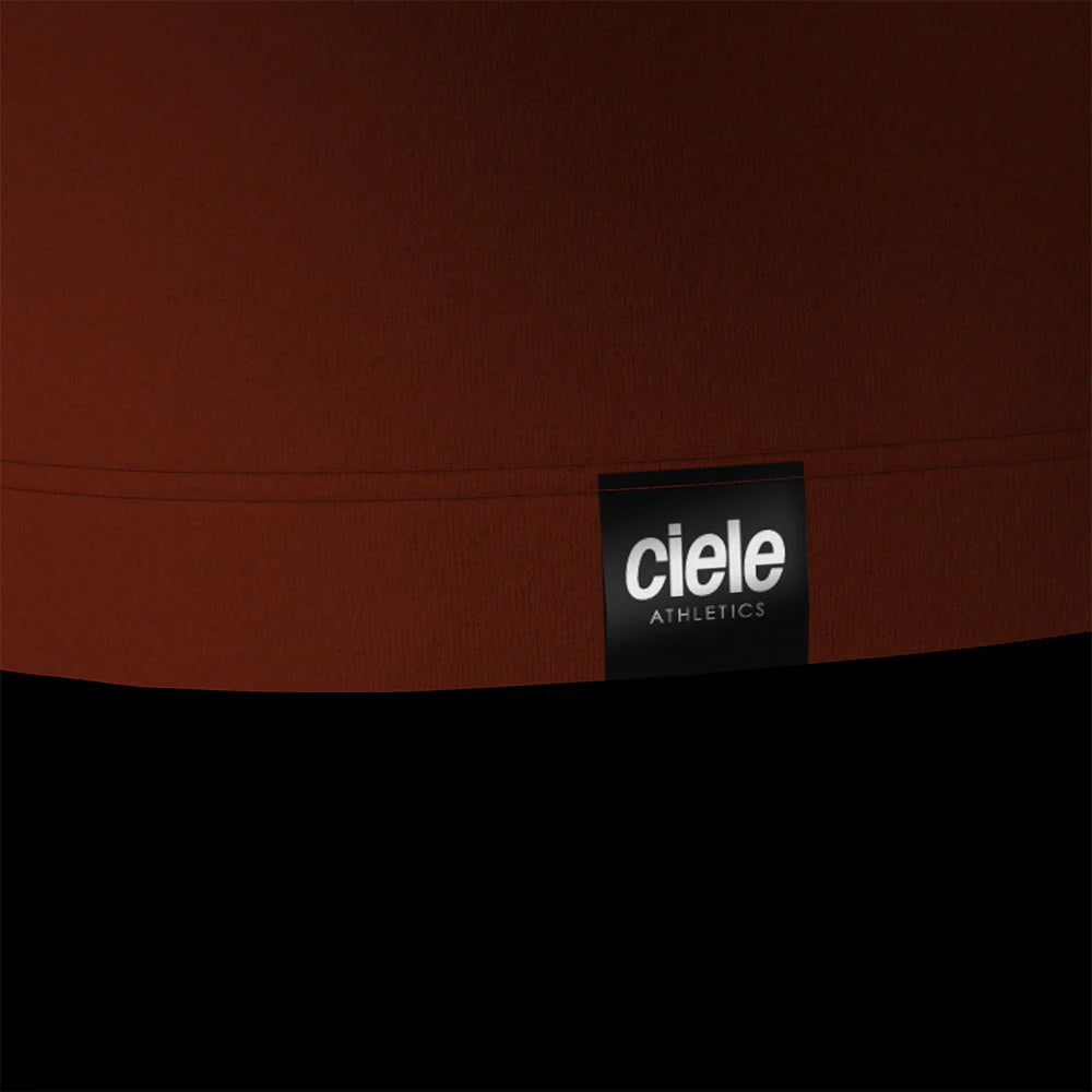 Ciele Athletics M DLYSinglet in Pulp from the rear on a dark background.