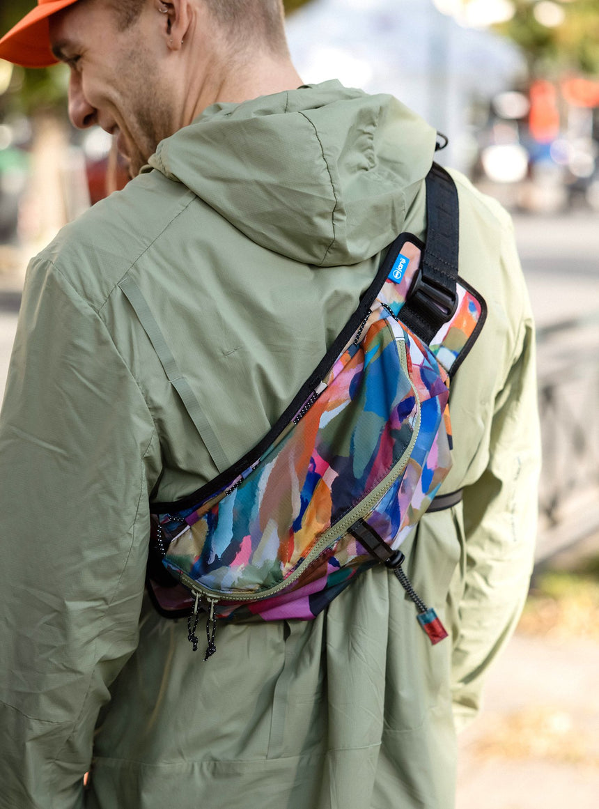 Janji Multipass Sling Bag worn by a man outdoors.