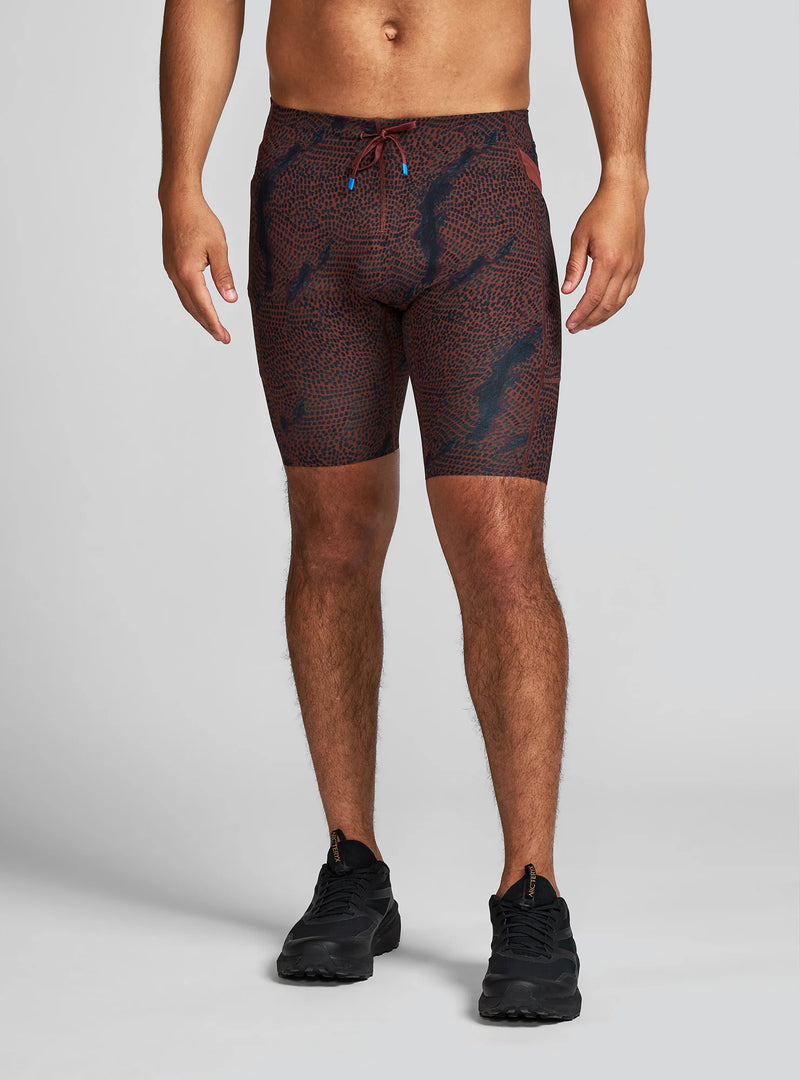 Janji Men's 8" Trail Half Tight in Shadowlands worn by a man on a neutral background.