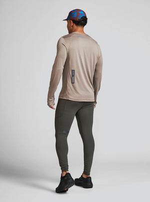 Janji M's Run All Day Long Sleeve in Silt from the rear being worn on a neutral background.