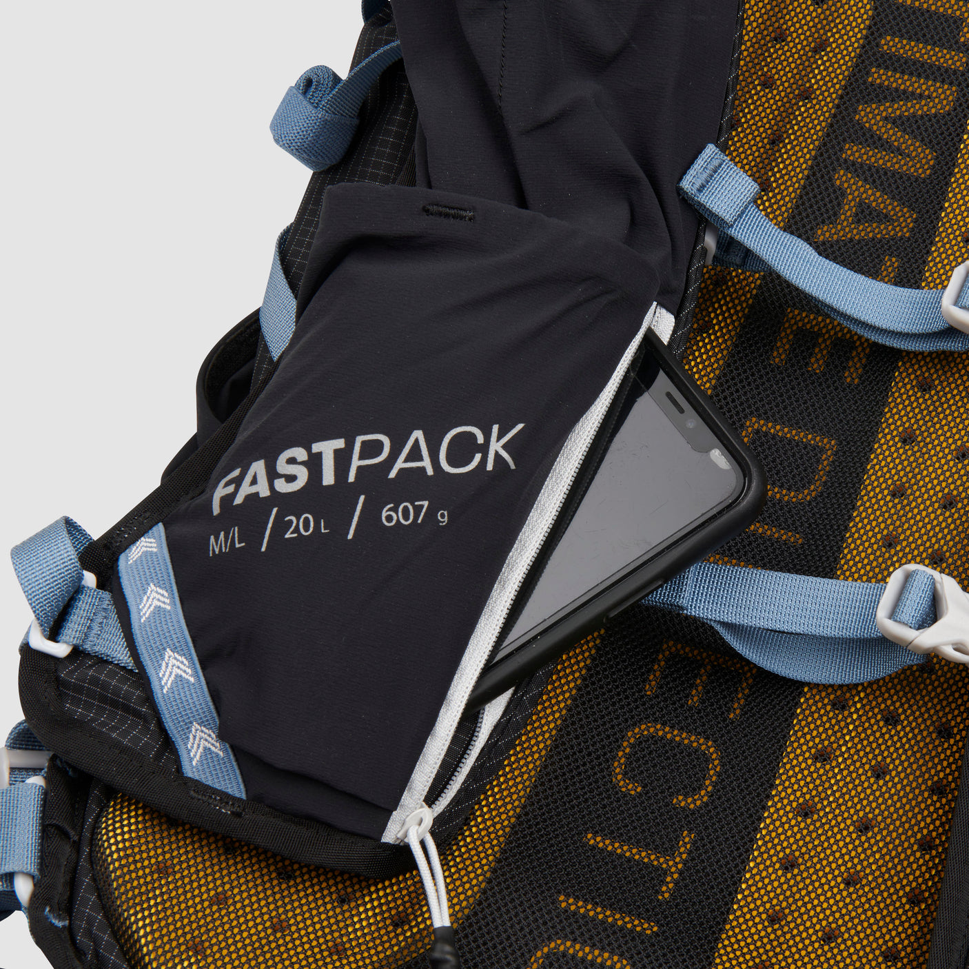 The Ultimate Direction Fastpack 20 on a neutral background with a closeup of the phone pocket.