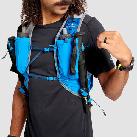 The Ultimate Direction Ultra Vest 6.0 on a neutral background being worn by a man.