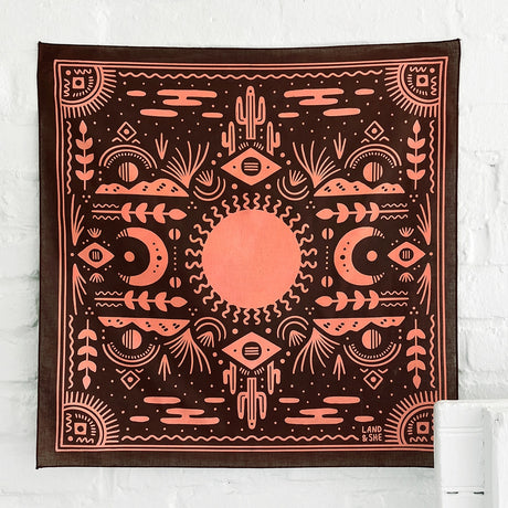 Land & She Western Sun Bandana on a neutral brick background.